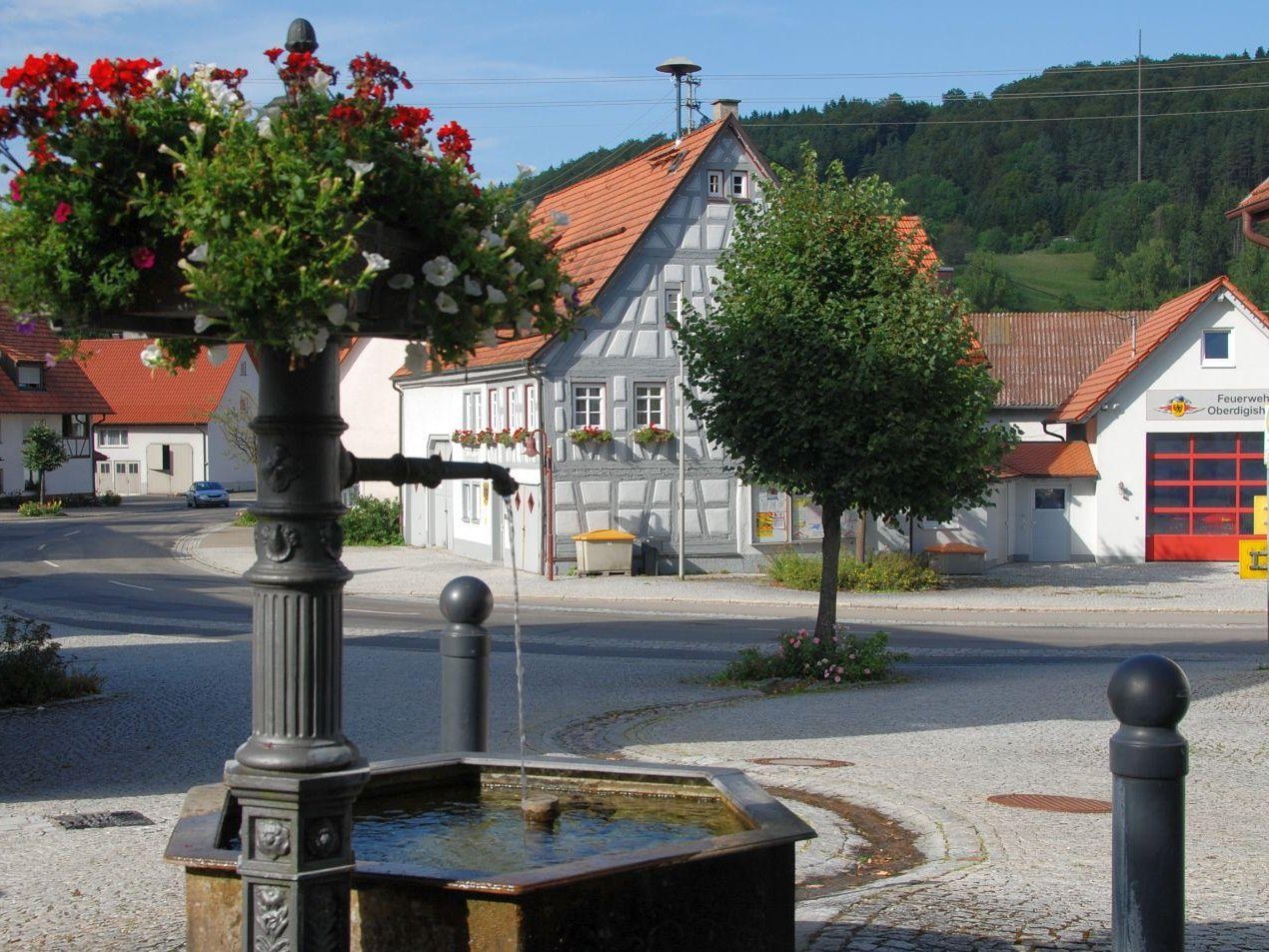 Brunnen in der Ortsmitte von Oberdigisheim - im Hintergrund das Rathaus und das Feuerwehrgerätehaus